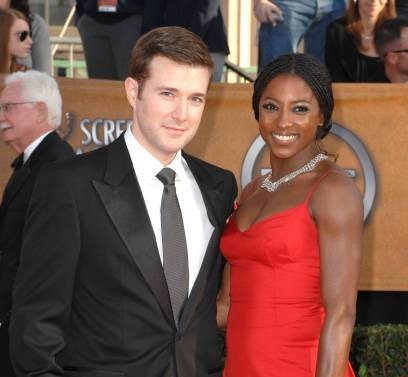 Jacob Fishel posing with his ex-wife by wearing black suit.